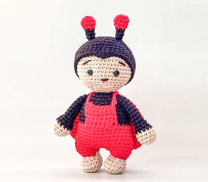 This visual displays a vibrant red and black crochet ladybug amigurumi, featuring a spotted shell and delicate handmade feel. As a part of our free pattern, this project is perfect for creating DIY gifts or nursery decor. You can access the complete row-by-row instructions and material list through our linked guide.
