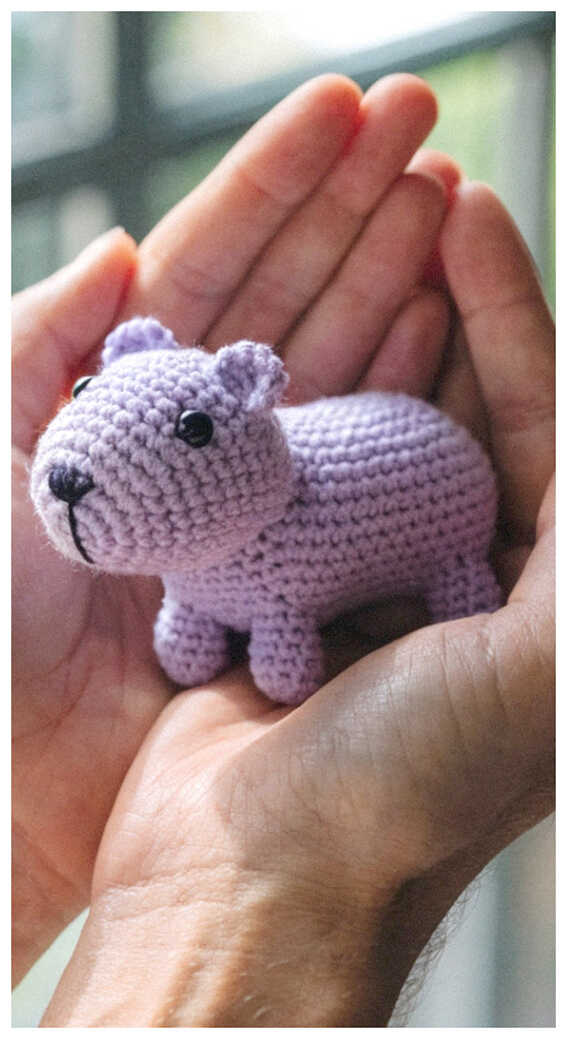 Mini capybara amigurumi crochet toy held in hand, a small handmade plush design loved for cute gifts and cozy decor accents
