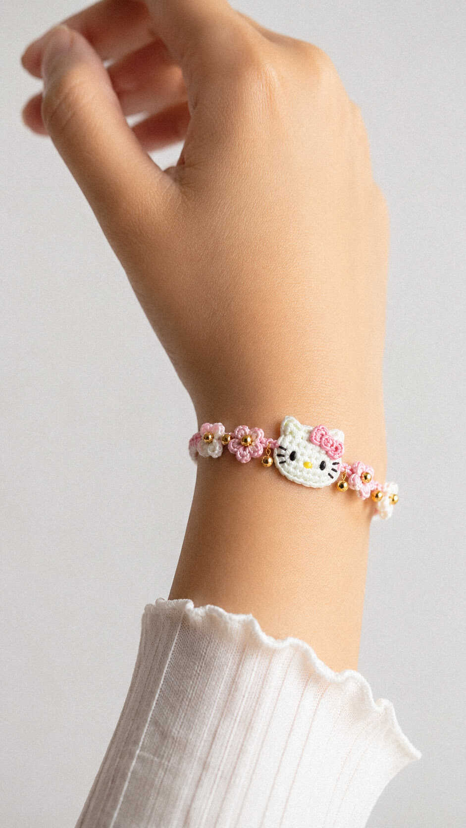 Free Hello Kitty flower bracelet crochet pattern with pink flowers and gold bead accents