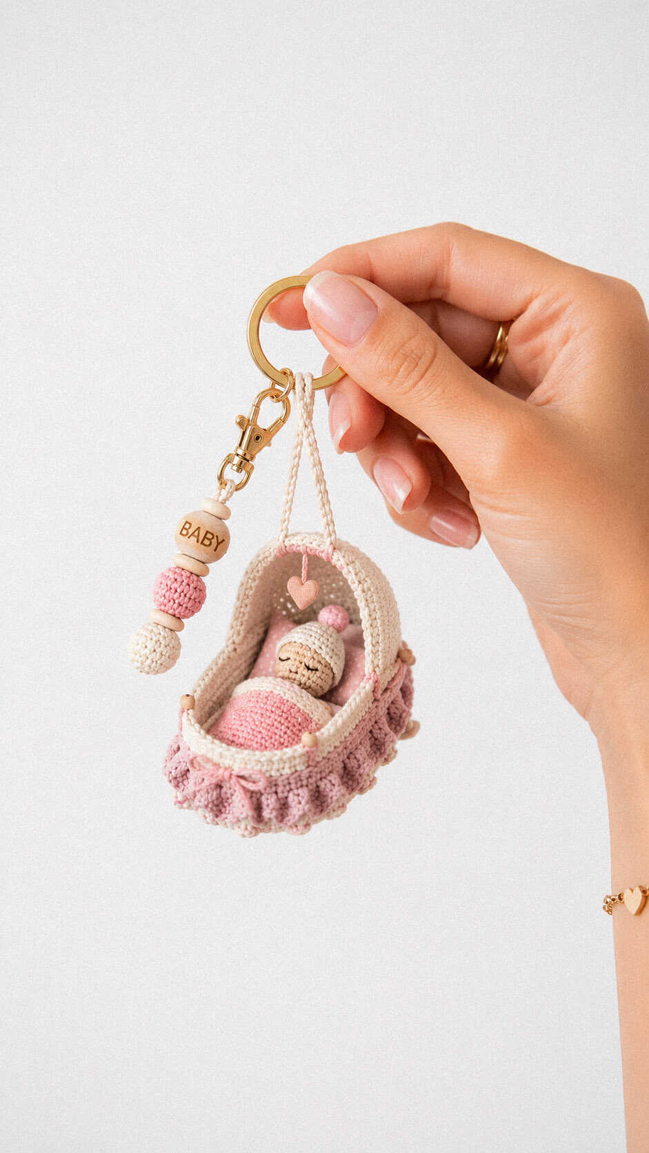 Tiny baby cradle keychain crochet pattern with sleeping crochet baby, pink blanket and BABY bead charm