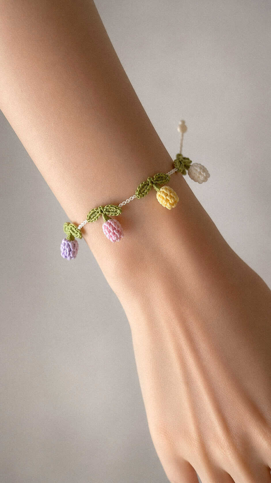 Pastel tulip crochet bracelet with lavender, pink, yellow and ivory flowers, handmade floral wrist accessory free crochet pattern.